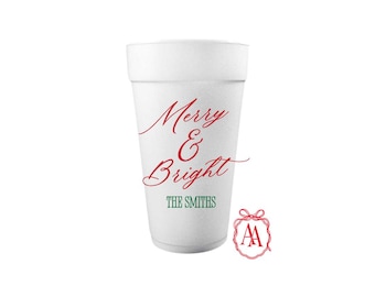 May include: A white foam cup with the words "Merry & Bright" in red script. Below, in green, is "THE SMITHS". A red and white logo is in the lower right corner. The cup is a festive item for the holiday season.