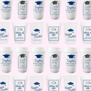 Peut inclure: Douze gobelets en mousse blanche avec des motifs sur le th&egrave;me de la remise des dipl&ocirc;mes. Les gobelets pr&eacute;sentent du texte et des graphismes bleus et noirs, y compris des chapeaux de graduation, les mots "F&eacute;licitations" et "Classe de 2025", ainsi que les noms "Taylor's" et "Maddiel".
