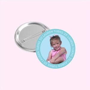 May include: A light blue button with a photo of a young girl smiling. The button has the text "21! Lauren Turns 21! Lauren Turns 21!" around the edge.