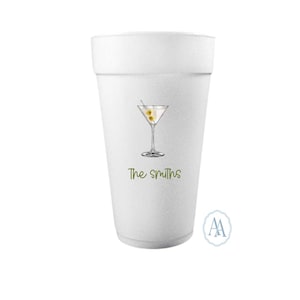Könnte beinhalten: Ein weißer Schaumstoffbecher mit einer Martini-Glas-Illustration und dem Text "The Smiths" in Grün. Das Martini-Glas hat Oliven. Ein kleines Logo befindet sich in der unteren rechten Ecke.