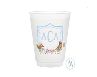 May include: A white plastic cup with a light blue crest design featuring the initials "ACA". The cup is decorated with a watercolor illustration of a dog, a basket of flowers, and an American flag.