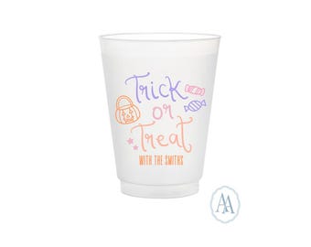 Pode incluir: Um copo de plástico branco com as palavras "Trick or Treat" em escrita roxa e laranja, juntamente com ilustrações de abóboras e doces. O texto "WITH THE SMITHS" é impresso abaixo em laranja. Um copo de festa com tema de Halloween.