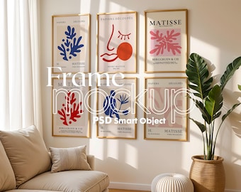 Puede incluir: Seis impresiones de arte enmarcadas con diseños abstractos en colores rojo, azul y rosa. Las impresiones están colgadas en una pared blanca en un ambiente de sala de estar con un sofá, una planta y un taburete.
