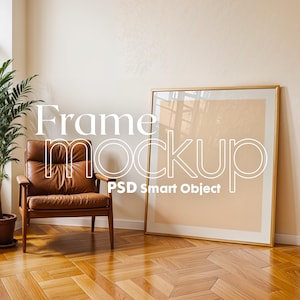 Pode incluir: Interior de uma sala com uma poltrona de couro castanho, uma planta alta em vaso e uma grande obra de arte emoldurada encostada a uma parede. A moldura tem acabamento dourado. O texto "Frame mockup PSD Smart Object" está sobreposto.