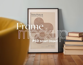 May include: A black framed poster with a geometric design in brown and white. The poster reads "bauhaus ausstellung WEIMAR JULI - SEPT 1923". The poster is sitting on a wooden floor.
