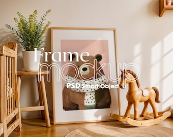 May include: A framed illustration of a brown bear wearing a green and white scarf. The frame is on a wooden floor next to a rocking horse.