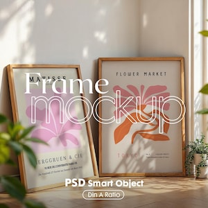 May include: Two framed art prints with wooden frames. The print on the left features a pink flower with the text "MATISSE" and "ERGGRUEN & CIE". The print on the right features an orange flower with the text "FLOWER MARKET" and "TOKYO".