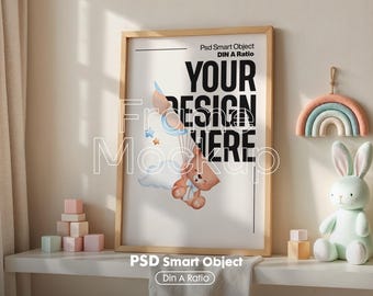 May include: A wooden frame mockup with a white background and the text "YOUR DESIGN HERE" in black. The frame is sitting on a shelf with a rainbow-colored felt rainbow decoration and a plush white bunny toy.