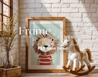 May include: A wooden frame with a white mat and a colorful illustration of a lion wearing a striped shirt. The frame is sitting on a wooden floor in front of a white brick wall. A white rocking horse with a brown saddle is in the foreground.