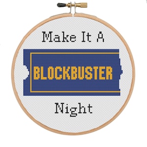 Puede incluir: Un aro de bordado blanco con un diseño de punto de cruz azul y amarillo. El diseño dice "Make It A Blockbuster Night".