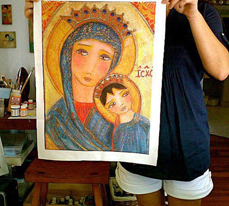 May include: A colorful religious icon print featuring the Virgin Mary and Child, both adorned with halos and crowns. The artwork has a gold background and is held up by a person. The image has the text "ICXC".