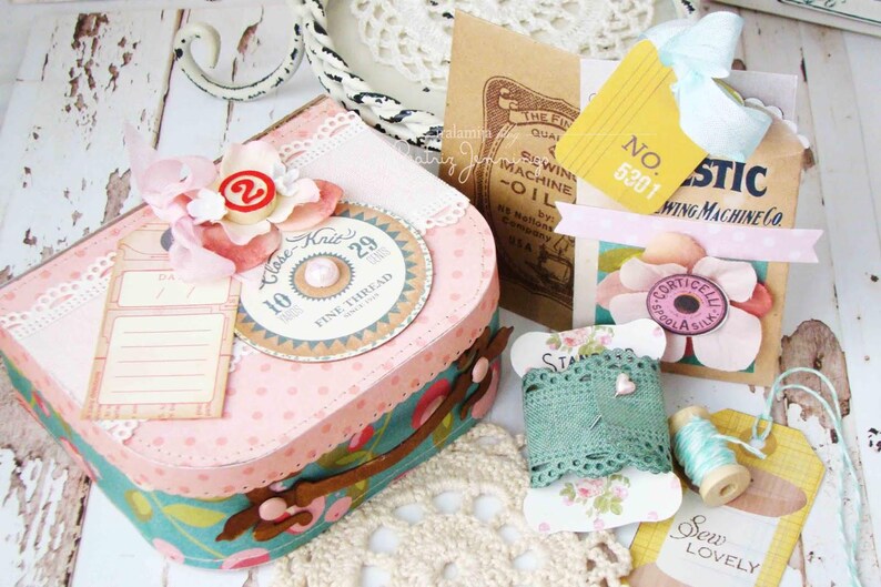 May include: A vintage-style craft box with a pink and white polka dot pattern, decorated with lace, flowers, and a sewing machine themed embellishment. The box has a label that says "Clase Knit 10 29 Fine Thread".