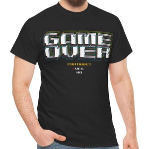 May include: Black t-shirt with a pixelated "GAME OVER" graphic in rainbow colors. The text "CONTINUE?" is below the graphic with "YES" and "NO" options.