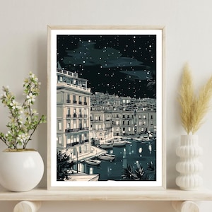 May include: A framed art print depicting a nighttime harbor scene. The illustration features buildings with lit windows, boats on the water, and a starry sky. The color palette includes shades of blue, white, and gray.