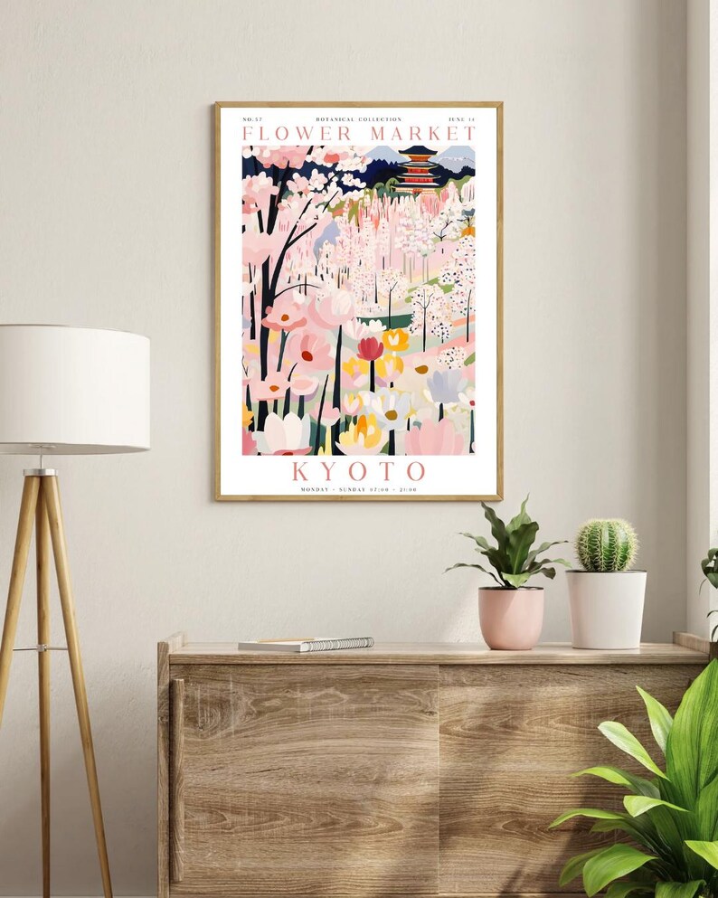 Op de afbeelding: Een vintage poster die reclame maakt voor een bloemenmarkt in Kyoto, Japan. De poster toont een kleurrijke illustratie van een bloemenmarkt met een pagode op de achtergrond. De tekst op de poster luidt "Bloemenmarkt, Kyoto, maandag - zondag 9:00 - 17:00".