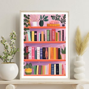 May include: A pink bookshelf with three shelves filled with books and plants. The shelves are made of wood and have a light pink background. There are various plants on the shelves, including a green plant with large leaves, a small potted plant with white flowers, and a green plant with small leaves. The books are all different colors and sizes, and some have titles visible.