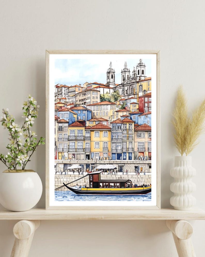 May include: A watercolor painting of a cityscape with colorful buildings and a boat on the water. The buildings are clustered together and have a variety of architectural styles. The boat is a traditional Portuguese boat with a yellow stripe and a brown hull.