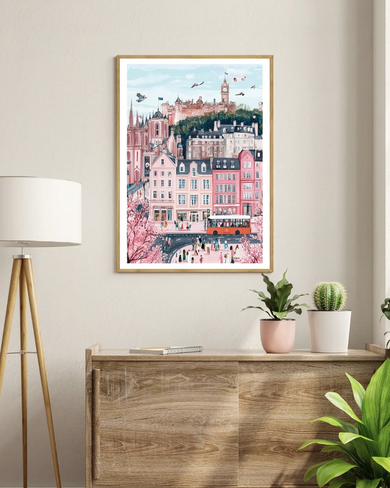 May include: A colorful illustration of a city scene with pink buildings, a red double-decker bus, and a castle in the background. The illustration features a street with people walking and trees with pink blossoms.
