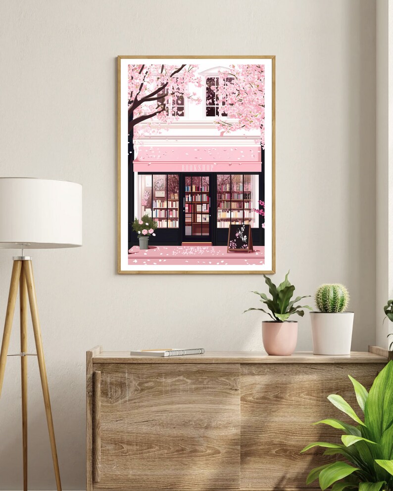May include: A pink storefront with a sign that reads "BOOKSHOP" surrounded by a cherry blossom tree. The storefront has a large window with bookshelves filled with books. The sidewalk is covered in pink cherry blossoms.