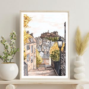 May include: A watercolour painting of a street scene in Edinburgh, Scotland. The painting shows a narrow street with stone steps leading up to a hilltop castle. The castle is in the background, and there are buildings on either side of the street. There is a street lamp on the right side of the street.