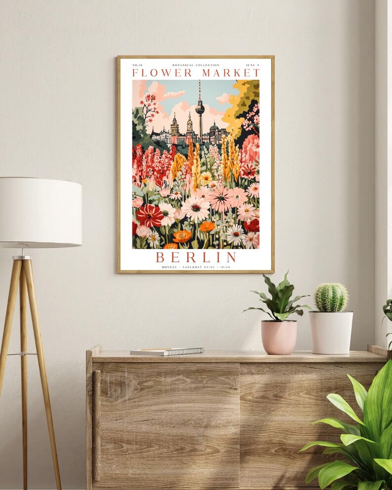 May include: A vintage-style poster advertising a flower market in Berlin, Germany. The poster features a colourful illustration of a flower garden with the Berlin TV Tower in the background. The text on the poster reads "Flower Market" and "Berlin".