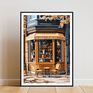 Op de afbeelding: Een winkelgevel met een gestreept luifel en grote ramen. De ramen tonen een verscheidenheid aan artikelen, waaronder boeken en planten. Twee rieten stoelen en een kleine tafel staan voor de winkel.