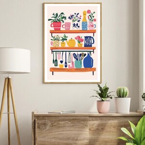 Puede incluir: Una ilustraci&oacute;n colorida de un estante de cocina con varias plantas, tazas, una tetera, una jarra y utensilios de cocina. El estante est&aacute; pintado de color rosa claro con un marco de madera.