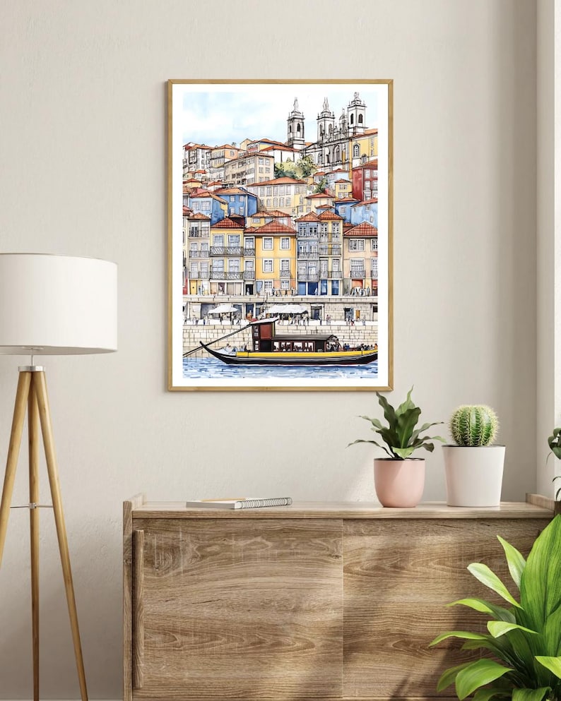 May include: A watercolor painting of a cityscape with colorful buildings and a boat in the foreground. The buildings are clustered together and have a variety of architectural styles. The boat is a traditional Portuguese boat with a yellow hull and a brown roof.