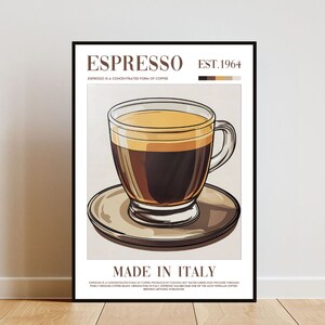 May include: A vintage-style poster with a black frame featuring a cup of espresso with a brown and beige background. The poster reads "Espresso Est. 1964" and "Made in Italy".