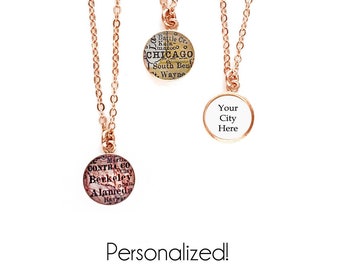 May include: Three gold necklaces with round pendants. The pendants feature vintage maps of Chicago, Berkeley, and a blank pendant that says "Your City Here".