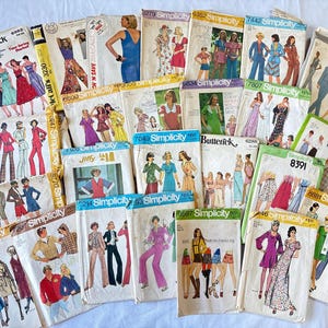 May include: A collection of vintage sewing patterns from brands like Simplicity and Butterick. The patterns feature illustrations of various 1970s and 1980s clothing designs, including dresses, jumpsuits, and suits. The patterns are in various sizes and styles.