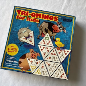 May include: A Tri-Ominos game for kids with a blue background and cartoon farm animals. The game includes triangular tiles with numbers and images. The box reads "No Reading Required".