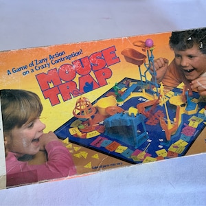 Peut inclure: Une boîte de jeu de société vintage pour Mouse Trap, un jeu d'action loufoque sur un engin fou. La boîte présente une illustration colorée du plateau de jeu et de deux enfants qui jouent. Le jeu est destiné aux enfants de 6 ans et plus et peut être joué par 2 à 4 joueurs.