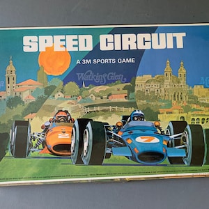 May include: A vintage board game box featuring a colourful illustration of two racing cars on a track. The game is called "Speed Circuit, A 3M Sports Game". The box shows the names of famous race tracks: Monza, Watkins Glen, and Monaco.