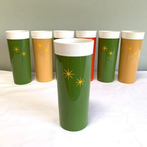 May include: Set of eight green, yellow and red plastic tumblers with white rims and a starburst design.