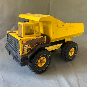 Camión volquete Mighty Tonka XMB-975 antiguo, de acero prensado y pintura amarilla original.