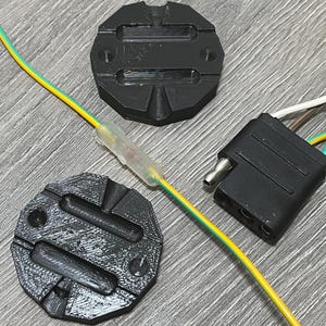 May include: Two black plastic wire crimpers with a yellow and green wire running through one of them.