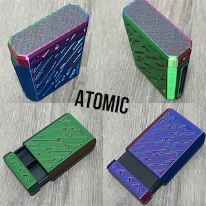 May include: Four metallic boxes in blue, green, and purple with a geometric design. The boxes have a sliding drawer and the word "ATOMIC" is printed in black.