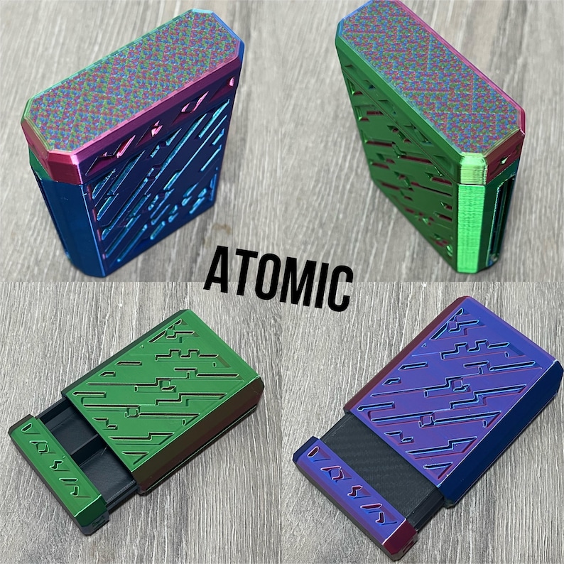May include: Four metallic boxes in blue, green, and purple with a geometric design. The boxes have a sliding drawer and the word "ATOMIC" is printed in black.