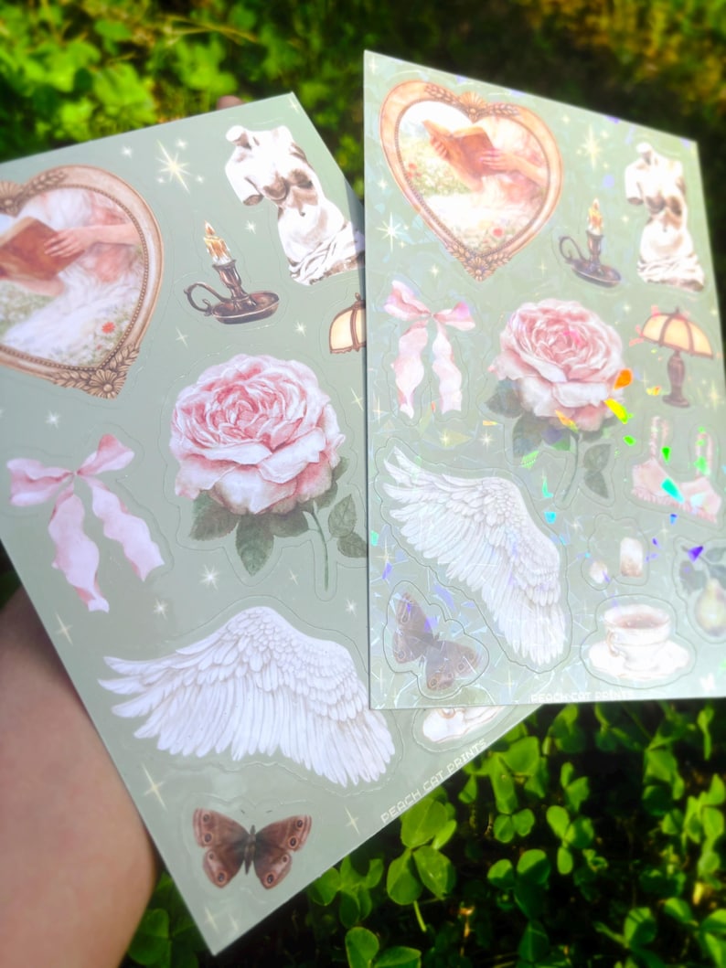 Puede incluir: Dos hojas de pegatinas con fondo verde claro. Cada hoja presenta varias pegatinas, incluyendo rosas rosas, alas de &aacute;ngel, mariposas e im&aacute;genes enmarcadas. Las pegatinas tienen una est&eacute;tica vintage con un toque de brillo.