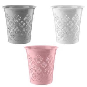 May include: Three decorative metal planters in grey, white, and pink. Each planter has a flared rim and a floral cutout pattern. The planters are empty and ready for use.