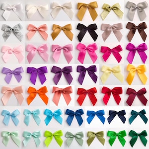 May include: Assortment of 36 satin ribbon bows in various colours, including silver, gold, pink, purple, orange, red, yellow, blue, green, and white. The bows are arranged in rows on a white background.