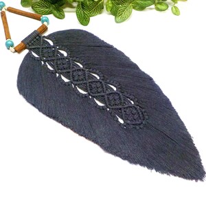 May include: A dark blue macrame feather wall hanging with wooden beads and turquoise accents.