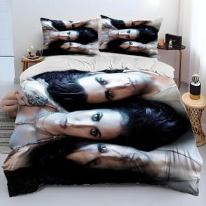 May include: A white bedding set with a black and white image of three people. The image features a couple and a woman with long dark hair. The image is printed on the duvet cover and pillowcases.