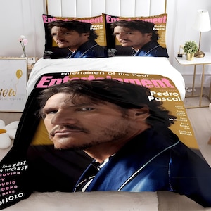 May include: A black and white bedding set with a magazine cover featuring Pedro Pascal on the front. The magazine cover is for Entertainment Weekly and features the text "Entertainers of the Year".