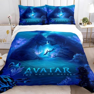 Op de afbeelding: Een blauwe en witte beddengoedset met een scène uit de film Avatar: The Way of Water. De afbeelding toont twee personages uit de film, een vrouw met blauwe huid en een man met blauwe huid, die elkaar onder water kussen. De tekst "Avatar: The Way of Water" is in wit op het beddengoed gedrukt.