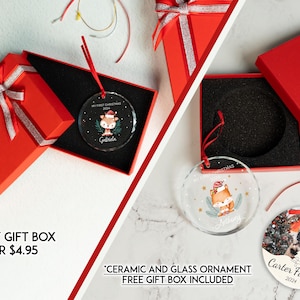 Puede incluir: Cajas de regalo rojas con cinta plateada y adornos navide&ntilde;os personalizados. Un adorno presenta una ilustraci&oacute;n de zorro, el otro una foto familiar. El texto en los adornos incluye nombres y "My First Christmas 2024".