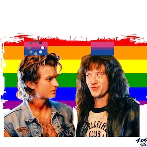 May include: Two men stand in front of a rainbow pride flag. The man on the left has short brown hair and is wearing a blue denim jacket. The man on the right has long brown hair and is wearing a black leather jacket with the text "Hellfire Club" on the front. Both men are smiling.