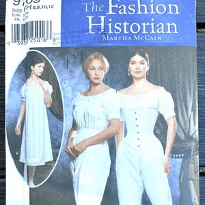May include: Simplicity sewing pattern featuring historical fashion designs. The cover shows illustrations of women in white dresses and undergarments. The text reads "The Fashion Historian" by Martha McCain.
