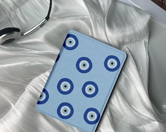 May include: A blue and white patterned notebook cover with a repeating design of evil eyes. The cover is made of a soft, textured material.